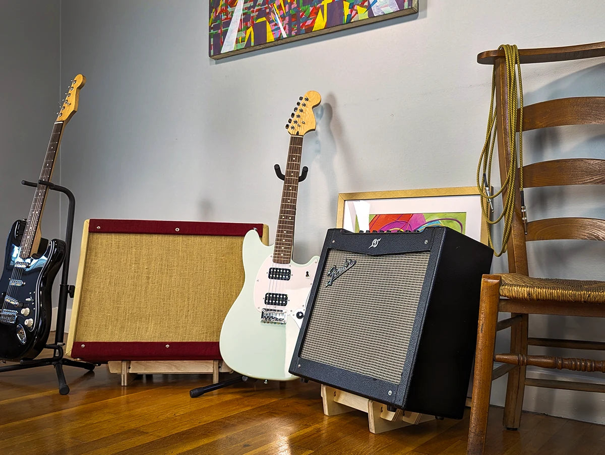 Two Wood Amp Stands and Two Guitars in a Rehearsal Space.